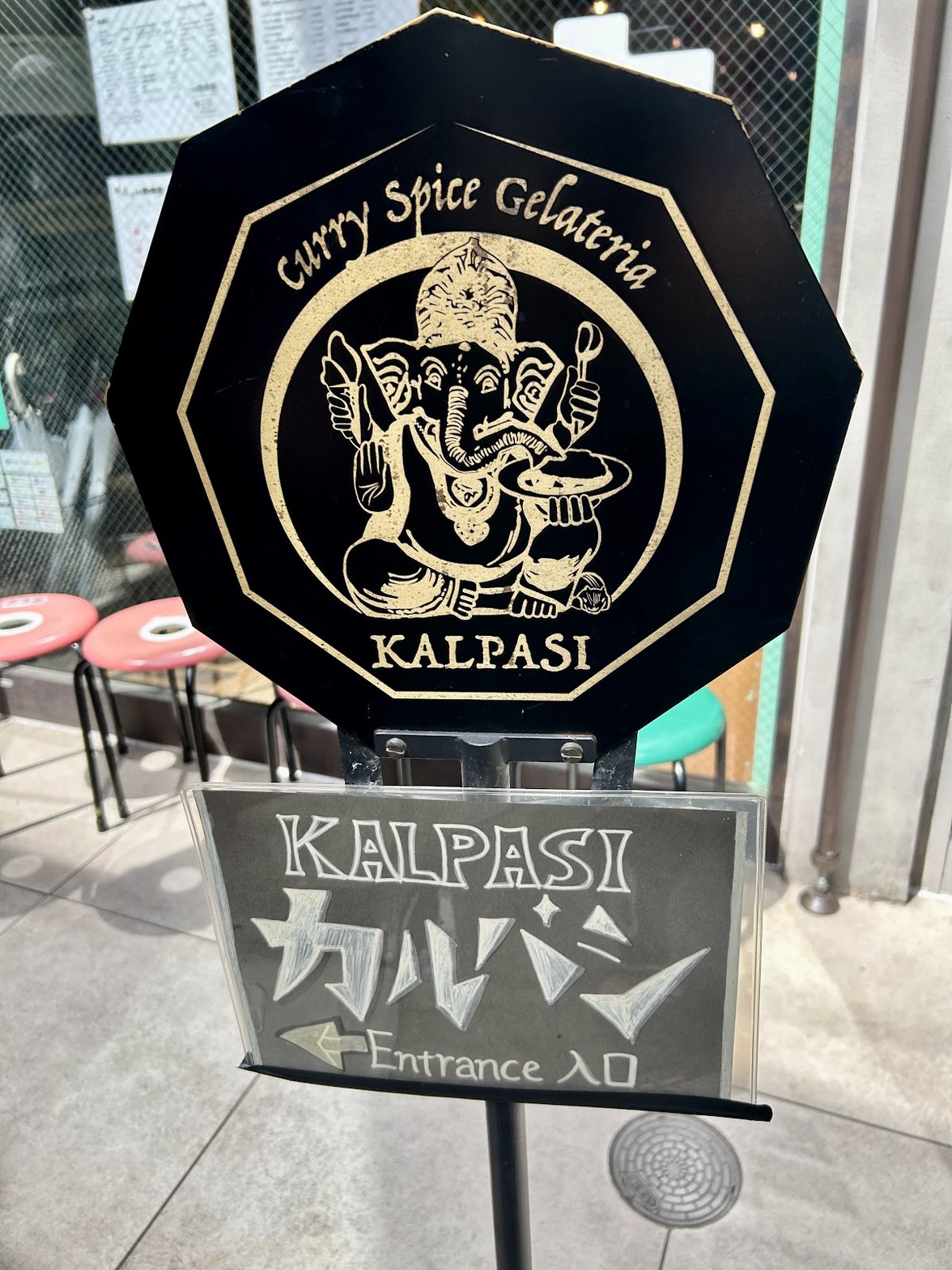 黒地にガネーシャのイラストと「KALPASI CURRY SPICE GELATERIA」の文字が金色で刻まれた八角形のサインボード